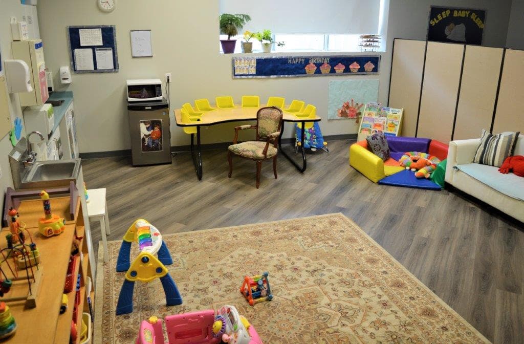 Infant room at KidLogic with a rocking chair, soft play mats and a quiet corner for settling